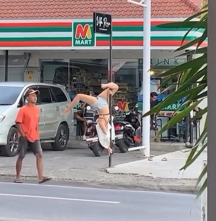 Viral Bule Meliuk Pole Dance di Tiang Papan Nama Toko Bali